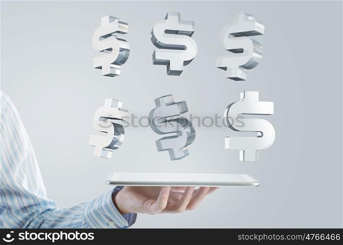 Tablet in hand with symbols. Close up of businessman hand holding tablet and glass dollar symbols