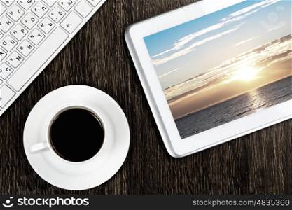 Tablet pc cup of coffee and keyboard at table. Office workplace