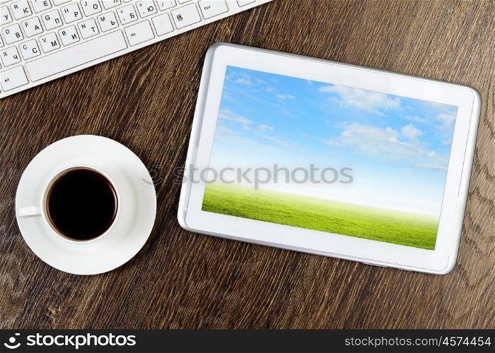 Tablet pc cup of coffee and keyboard at table. Work place