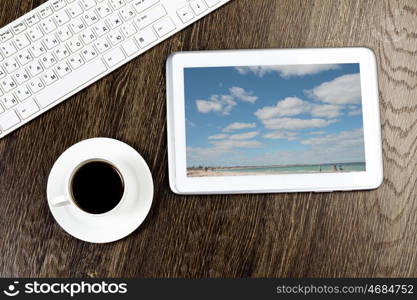 Tablet pc cup of coffee and keyboard at table. Work place