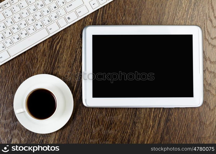 Tablet pc cup of coffee and keyboard at table. Work place