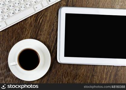 Tablet pc cup of coffee and keyboard at table. Work place