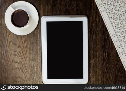 Tablet pc cup of coffee and keyboard at table. Work place