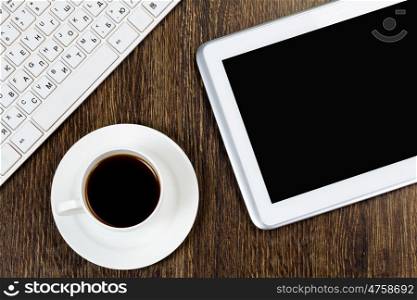 Tablet pc cup of coffee and keyboard on table. Work place