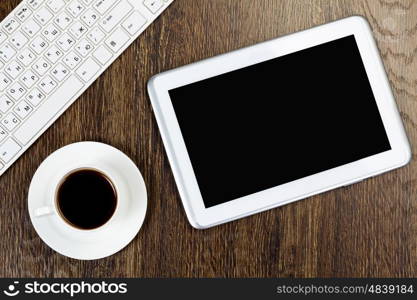 Tablet pc cup of coffee and keyboard on table. Work place