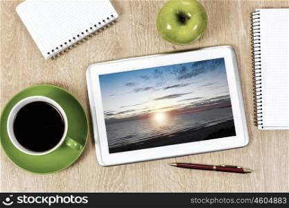 Tablet pc cup of coffee and notepad at table. Office workplace