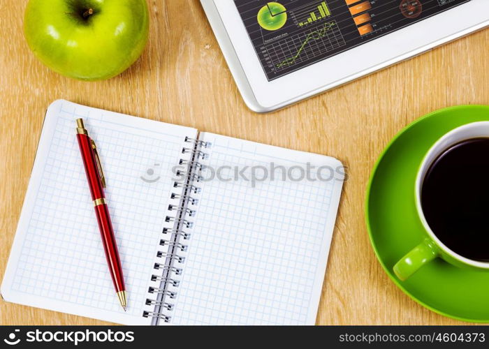 Tablet pc cup of coffee and notepad at table. Work place