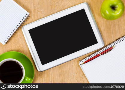 Tablet pc cup of coffee and notepad at table. Work place