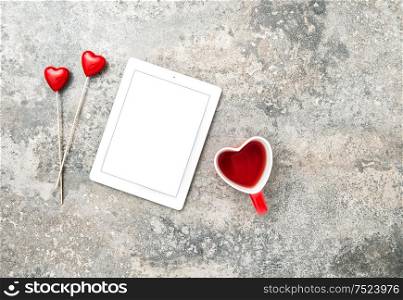 Tablet PC with red hearts decoartion and cup of tea. Valentines Day concept with space for your text and image