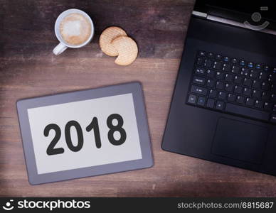 Tablet touch computer gadget on wooden table, vintage look - 2018