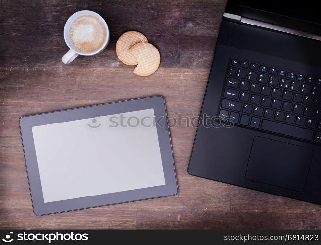 Tablet touch computer gadget on wooden table, vintage look