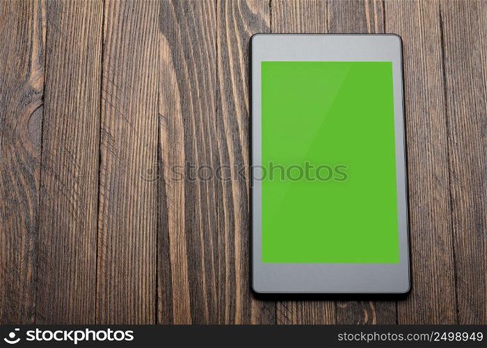 Tablet with blank screen on wooden table