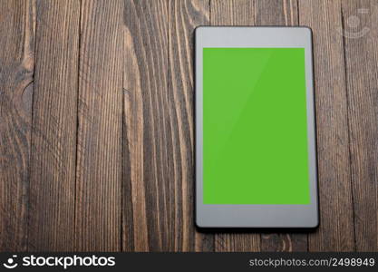 Tablet with blank screen on wooden table