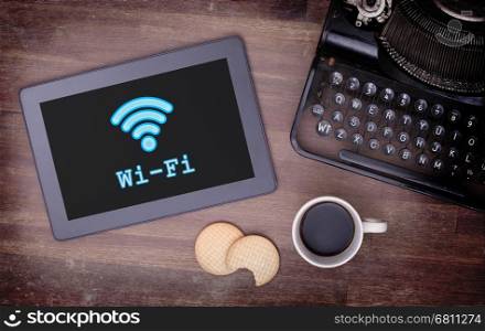 Tablet with Wi-Fi connection on a wooden desk,vintage setting