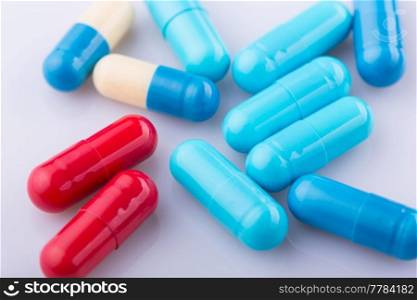 Tablets pills capsule heap mix therapy drugs, over a white background