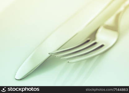 Tableware, cutlery, fork and knife on a white background toned