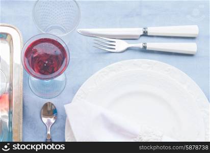 Tableware for dinner with set of plates, cutlery and champagne close up