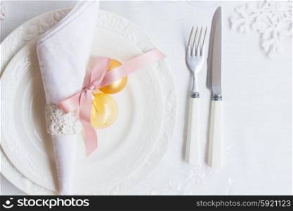 Tableware set. Plates and knofe with fork on white tablecloth with christmas decorations