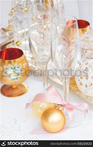 Tableware set. Tableware for christmas - two empty campagne glasses and christmas golden decorations