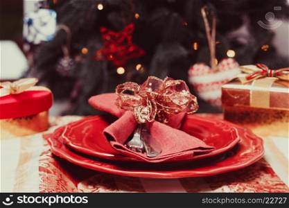 Tableware that performed in red on a background of the Christmas tree. The Christmas tableware
