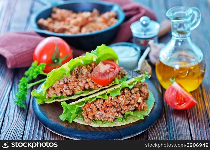 taco with meat and tomato on a table
