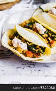 Tacos with chicken and vegetables on white wooden background