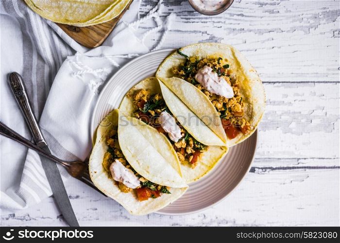Tacos with chicken and vegetables on white wooden background