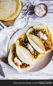 Tacos with chicken and vegetables on white wooden background