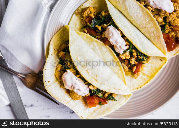 Tacos with chicken and vegetables on white wooden background