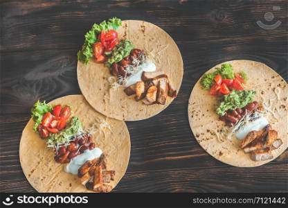 Tacos with fillings on the wooden table
