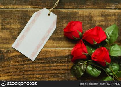 Tag template next to a red bouquet of roses on a rustic wood background