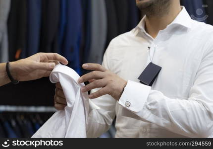 tailor delivering the white shirt to a customer