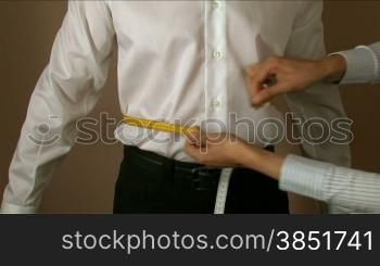 Tailor measuring different parts or the body for a shirt production.Measures for making men&acute;s shirts.Tailoring Jobs. Textile confection.