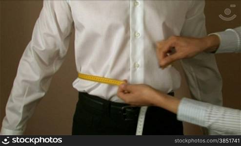 Tailor measuring different parts or the body for a shirt production.Measures for making men&acute;s shirts.Tailoring Jobs. Textile confection.