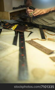 Tailor process leather in workshop. Making leather products.