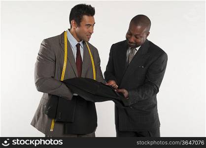 Tailor showing man a black suit