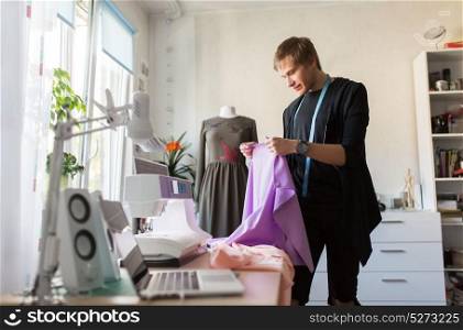 tailoring, sewing and clothing concept - fashion designer with cloth and measuring tape making new dress at home studio or workshop. fashion designer with cloth making dress at studio