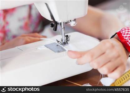 Tailors studio. Close up of woman dressmaker hands working with sewing machine