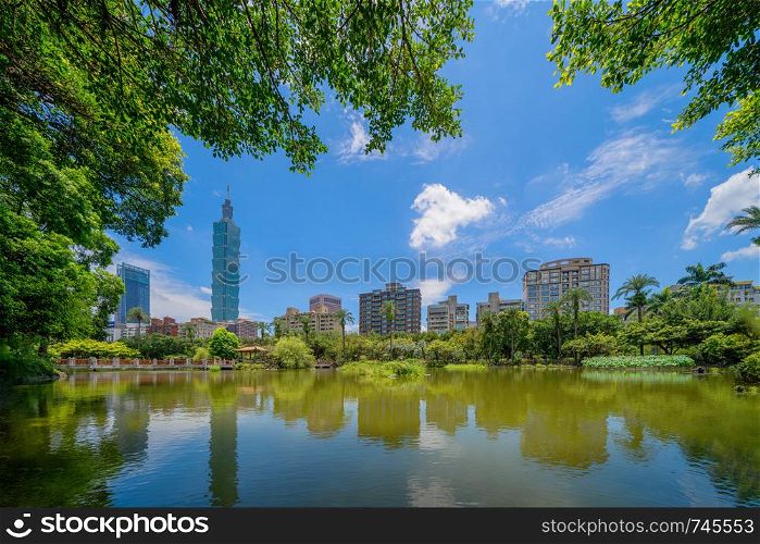 Taipei park garden and reflection of skyscrapers buildings. Financial district and business centers in smart urban city at noon, Taiwan.