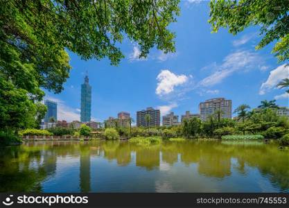 Taipei park garden and reflection of skyscrapers buildings. Financial district and business centers in smart urban city at noon, Taiwan.