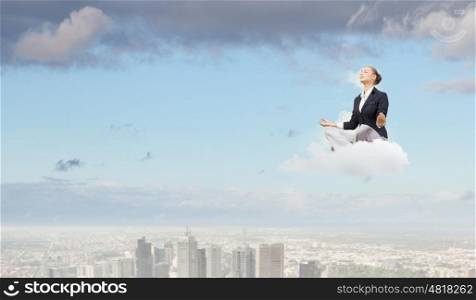 Take a break and relax. Young attractive woman sitting on cloud and meditating