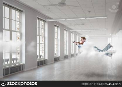 Take a break and relax. Young businessman flying in modern office and playing violin