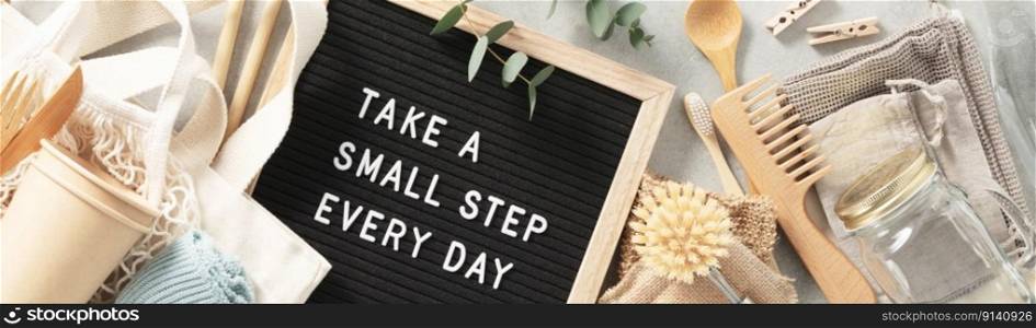 Take a small step every day letter board and Plastic free set with cotton bags, glass jars, green leaves and recycled tableware top view. Zero waste, eco friendly concept. Flat lay.