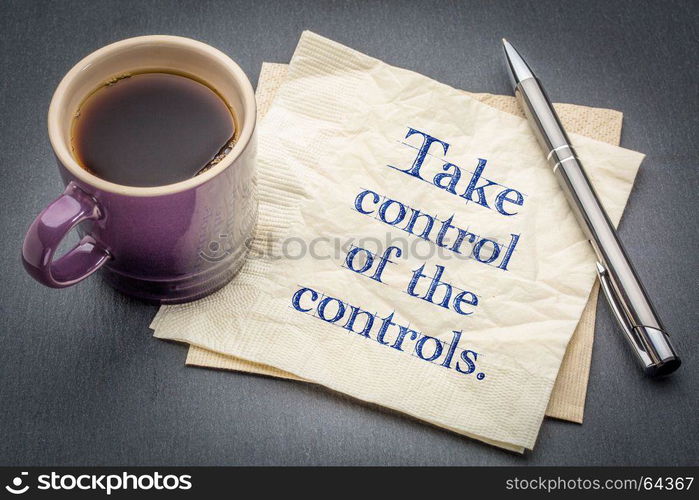 Take control of the controls - handwriting on a napkin with cup of coffee against gray slate stone background