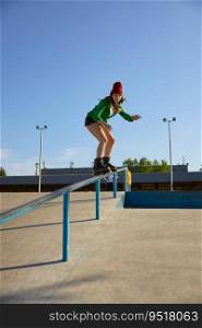 Talented teenager girl riding on handrail practicing extreme tricks. Dangerous roller skating stunt. Teenager girl in roller skates riding on handrail practicing extreme tricks