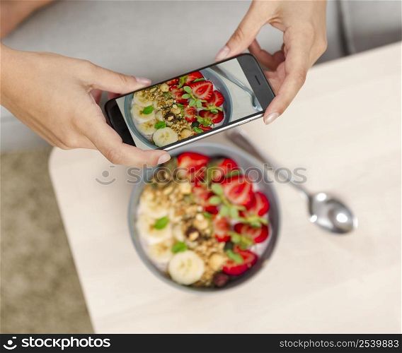 Talking picture to her food with a cellphone