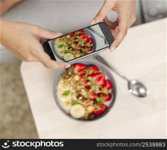 Talking picture to her food with a cellphone