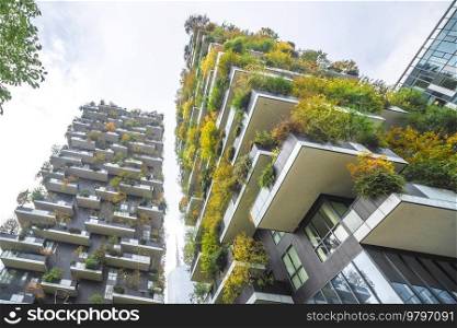 Tall buildings with green plants in the big city on a bright day