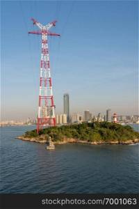Tall electricity power tower on small island in harbor of Xiamen in China. Tall electricity pylon in harbor of Xiamen China