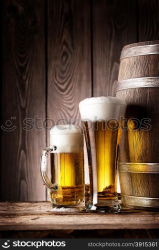 Tall glass and mug beer on the background of wooden barrels. Tall glass and mug beer